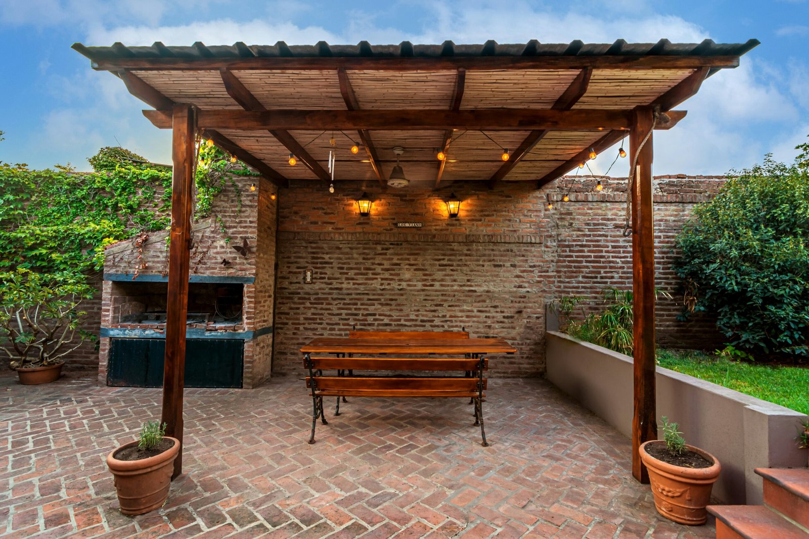 a wooden bench sitting under a wooden pergoline